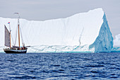 Ship sailing near majestic iceberg on