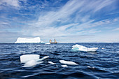 Sailboat among melting polar ice on