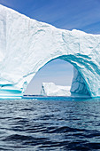 Majestic iceberg arch over blue Atlantic Ocean Greenland