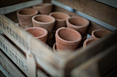Close up rustic clay flowerpots in crate