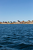 Houses on remote ocean coastline Disko Bay West Greenland