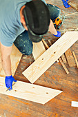 Carpenter marking and cutting floorboards