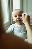 Portrait mother feeding baby daughter