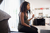 Young pregnant woman in living room