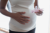 Pregnant woman with pill box taking prenatal vitamins