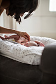 Mother watching cute newborn baby son in bassinet