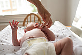 Mother holding hands with newborn baby son