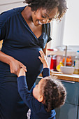 Curious daughter touching pregnant mother stomach