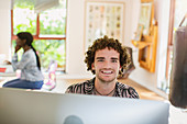 Portrait happy man working from home at computer