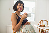 Portrait happy pregnant woman drinking tea