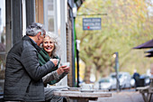 Senior couple drinking coffee at sidewalk cafe