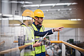 Male supervisors talking on platform in factory