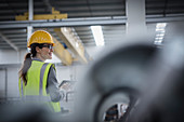 Confident female worker in steel factory