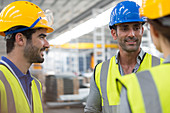 Smiling workers talking in factory