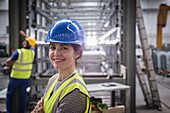 Portrait smiling, confident female worker in factory