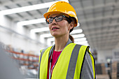 Female worker looking away in factory