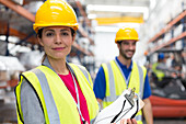 Confident female supervisor with clipboard in warehouse