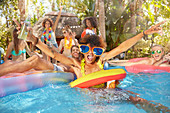 Young friends drinking and playing in summer swimming pool