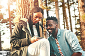 Young couple texting with smart phone in woods