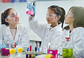 Girl students conducting scientific experiment in classroom