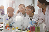 Female teacher and students watching scientific experiment