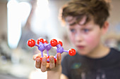 Boy student holding and examining molecular structure