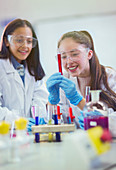 Students examining liquid in test tube in classroom