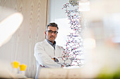 Male science teacher standing behind molecular structure