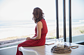 Brunette woman looking at ocean view from dining room table