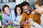 Laughing family drinking healthy green smoothie in kitchen