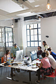 Designers working at computers in open plan office