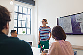 Female architect at television screen leading meeting