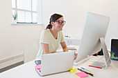 Smiling businesswoman working at computer in office