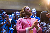 Smiling man clapping in audience
