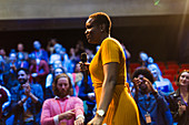 Female speaker with microphone on stage