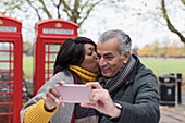 Couple kissing and taking selfie in park