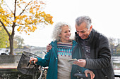 Adventurous senior couple with bicycles looking at map