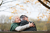 Affectionate, tender senior couple hugging in autumn park