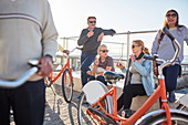 Active senior friend tourists with bicycles eating ice cream