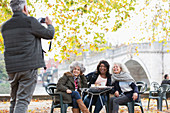 Senior man photographing active senior women friends
