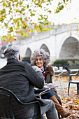 Senior couple enjoying coffee at autumn park cafe