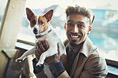 Portrait smiling young man holding dog