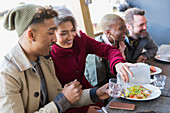 Smiling young couple dining at restaurant outdoor cafe