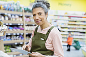 Female grocer with digital tablet working in supermarket