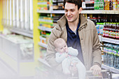 Father and baby daughter shopping in supermarket