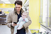 Father with baby daughter shopping in supermarket