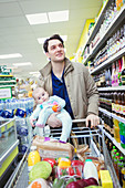 Father and baby daughter shopping in supermarket