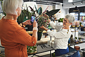 Senior women with camera phone in home decor shop