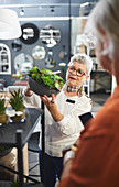 Worker showing plants to customer in home decor shop