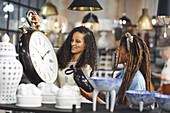 Women shopping for wall clocks in home decor shop
